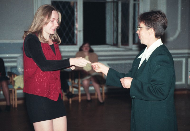 1998. gada Jaunā studenta svētki / Aristoteļa svētki. Studente saņem studentu apliecību no filoloģijas fak. dekānes Daces Lūses.