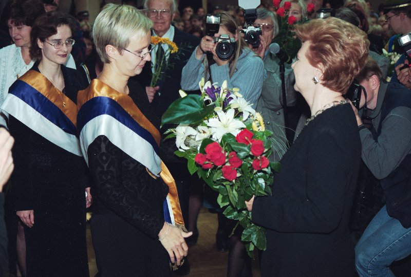 LU 81. gadskārtai veltītā Senāta svinīgā sēde. Latvijas Valsts prezidenti Vairu Vīķi-Freibergu pēc LU Goda doktores diploma saņemšanas sveic studenšu korporācijas 'Spīdola' pārstāves.