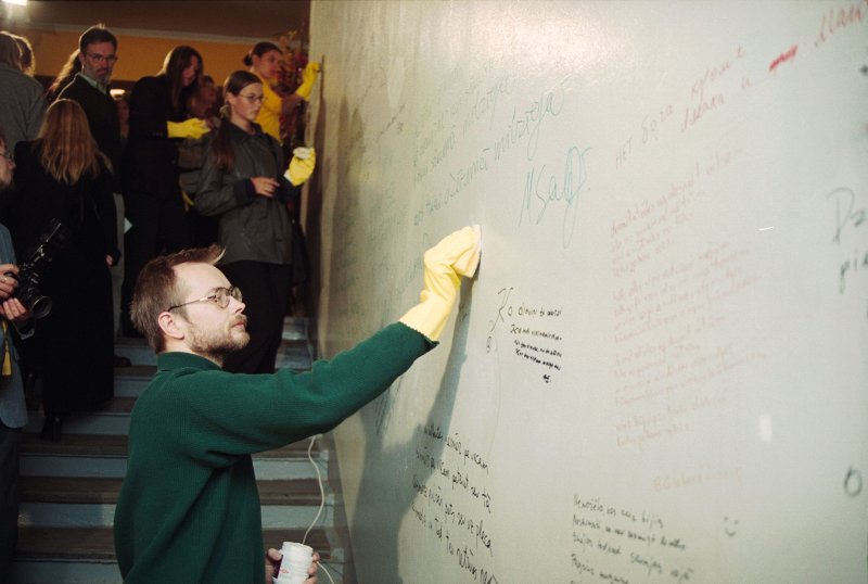 Latvijas Dzejas dienu ietvaros notiekošais sarīkojums LU Filoloģijas fakultātē. Uz fakultātes sienām uzrakstīto 'nevārdu' notīrīšana. Priekšplānā - dzejnieks Māris Salējs.