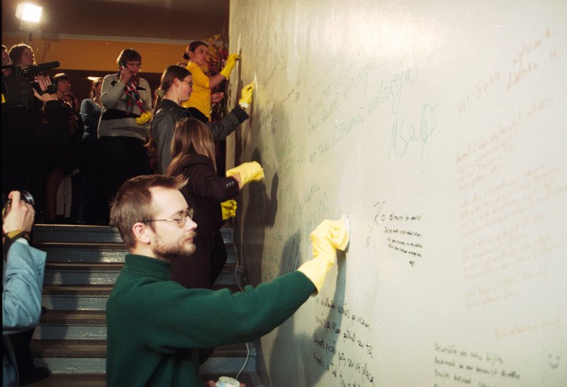 Latvijas Dzejas dienu ietvaros notiekošais sarīkojums LU Filoloģijas fakultātē. Uz fakultātes sienām uzrakstīto 'nevārdu' notīrīšana. Priekšplānā - dzejnieks Māris Salējs.