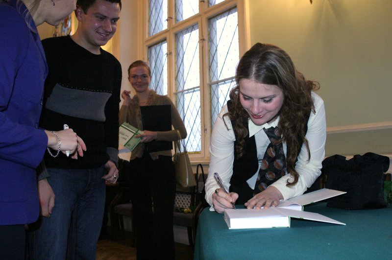 Grāmatas 'Eiropas vides tiesības' atvēršana. No lab.: Elīna Ūsiņa ieraksta autogrāfu.