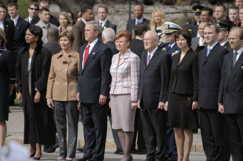 Amerikas Savienoto valstu (ASV) prezidenta Džorža Buša (George W. Bush
) vizīte Latvijā. Ziedu nolikšana pie Brīvības pieminekļa. No kreisās:
Kondolīza Raisa (Condoleezza Rice), ASV valsts sekretāre; 
Lura Buša (Laura Bush), Džordža Buša sieva; 
Džordžs Bušs; 
Vaira Vīķe-Freiberga, Latvijas Valsts prezidente; 
Imants Freibergs, Vairas Vīķes-Freibergas vīrs; 
Aiva Rozenberga, Latvijas Valsts prezidenta preses sekretāre; 
Andrejs Pildegovičs, Latvijas Valsts prezidenta padomnieks ārlietu jautājumos; 
Jānis Dripe, Valsts protokola vadītājs.