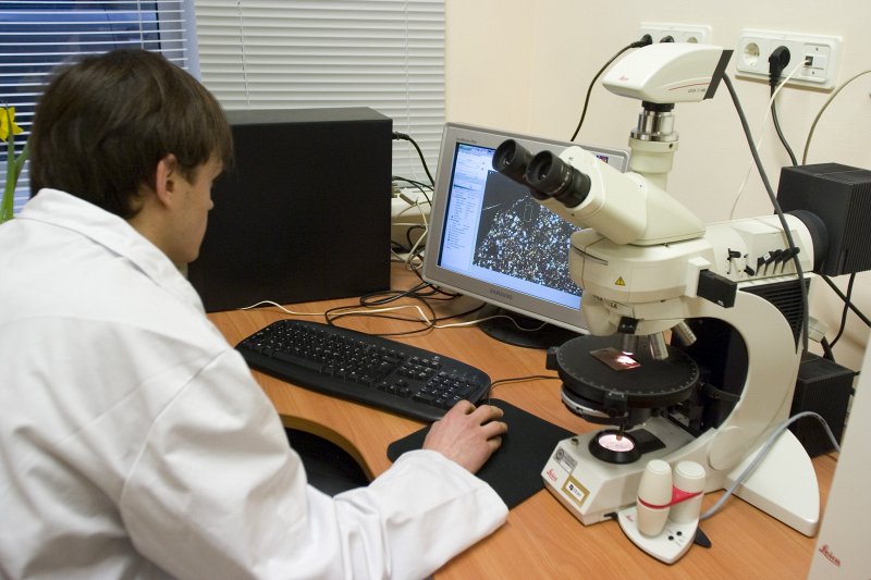 LU Ģeogrāfijas un Zemes zinātņu fakultātes Iežu pētījumu laboratorijas vadītājs, Ģeoloģijas doktorants Andis Kalvāns darbā ar mineroloģisko polarizāzcijas mikroskopu. null