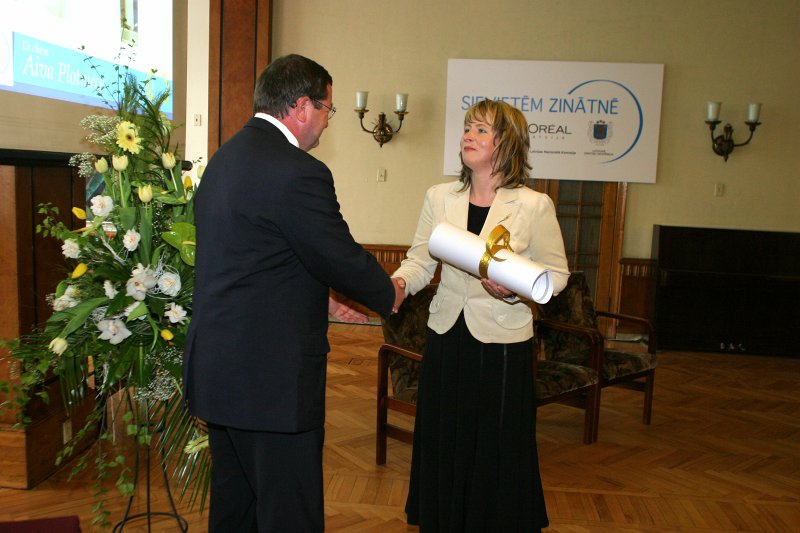 2007.gada L’Oréal Latvijas stipendijas 'Sievietēm Zinātnē' pasniegšanas ceremonija Latvijas Zinātņu akadēmijā. No kreisās: 
Eriks Delamars (Eric Delamare), SIA L’Oréal Baltic ģenerāldirektors un
stipendijas saņēmēja
Aiva Plotniece, Organiskās sintēzes institūta Membrānaktīvo savienojumu un β-diketonu laboratorijas vadošā pētniece, ķīmijas doktore.