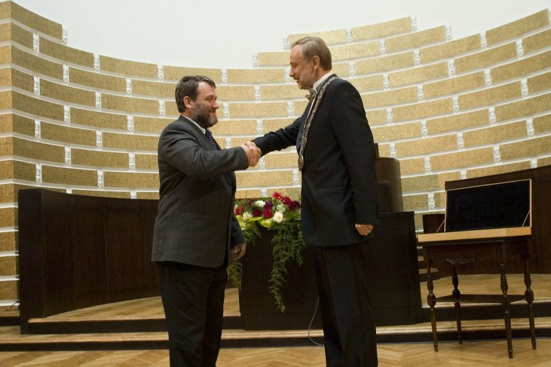 LU darbinieku ikgadējā sanāksme. No kreisās: LU Senāta priekšsēdētājs Juris Rozenvalds sveic LU rektoru Mārci Auziņu.