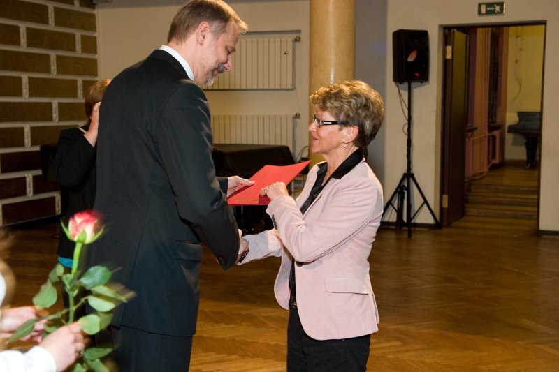 LU darbinieku sapulce. LU rektors Mārcis Auziņš (no kreisās) pasniedz pateicības rakstu Edītei Simanovičai.