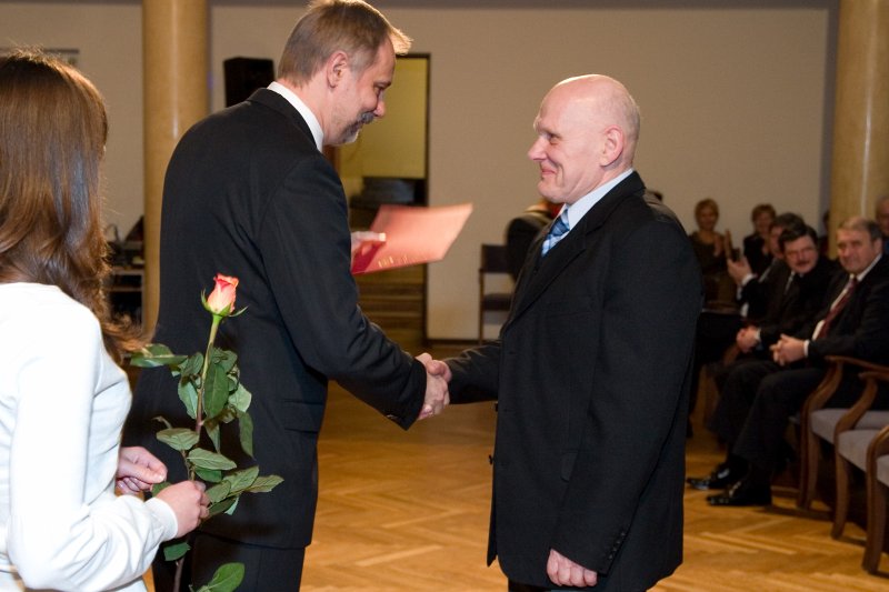 LU darbinieku sapulce. LU rektors Mārcis Auziņš (no kreisās) pasniedz pateicības rakstu Laimonim Freimanim.