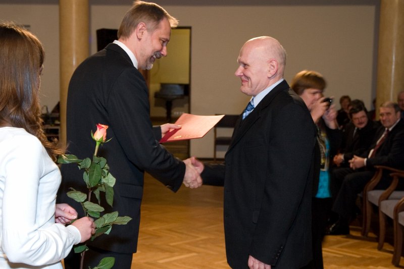 LU darbinieku sapulce. LU rektors Mārcis Auziņš (no kreisās) pasniedz pateicības rakstu Laimonim Freimanim.