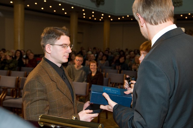 LU darbinieku sapulce. Gada balvas zinātnē pasniegšana. LU rektors Mārcis Auziņš (no labās) pasniedz balvu dr. Robertam Spirģim.