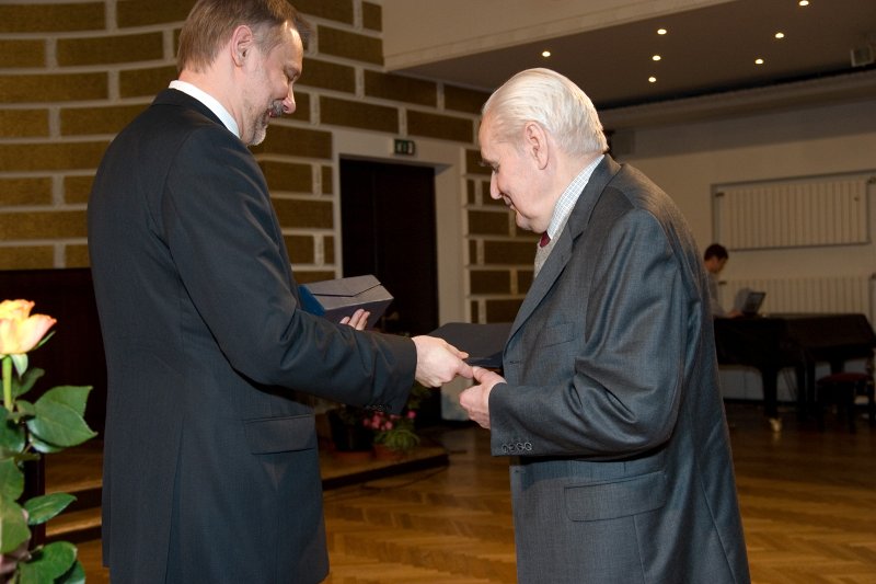 LU darbinieku sapulce. Gada balvas zinātnē pasniegšana. LU rektors Mārcis Auziņš (no kreisās) pasniedz balvu prof. Mārtiņam Beķerim.
