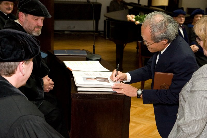 LU 89. gadadienai veltīta Senāta svinīgā sēde. LU Goda doktors, Kioto Universitātes profesors Kazuo Iwama parakstās LU Goda doktoru grāmatā.