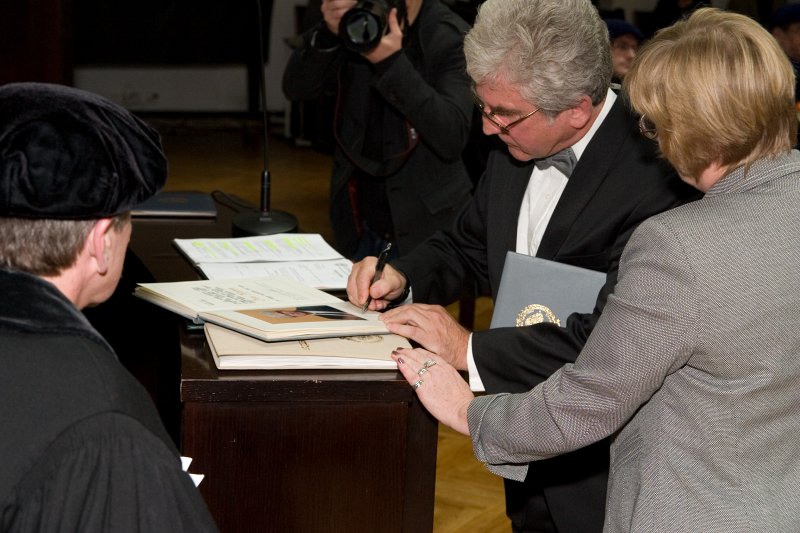 LU 89. gadadienai veltīta Senāta svinīgā sēde. LU Goda biedrs, Latvijas Mūzikas akadēmijas profesors, LU koru 'Juventus' un 'Jubilate' mākslinieciskais vadītājs Juris Kļaviņš parakstās LU Goda biedru grāmatā.