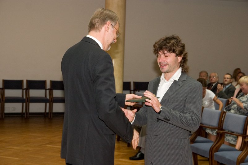 LU darbinieku sapulce. LU rektors Mārcis Auziņš (pa kreisi) pasniedz asociētā profesora diplomu Vadimam Danovičam.