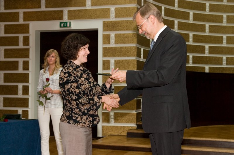 LU darbinieku sapulce. LU rektors Mārcis Auziņš (pa labi) pasniedz asociētā profesora diplomu Darjai Šmitei.