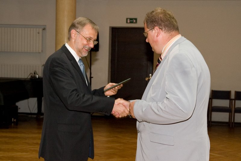 LU darbinieku sapulce. LU rektors Mārcis Auziņš (pa kreisi) pasniedz asociētā profesora diplomu Jānim Taurēnam.