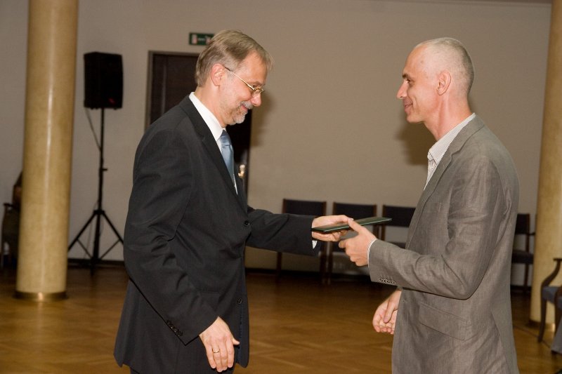 LU darbinieku sapulce. LU rektors Mārcis Auziņš (pa kreisi) pasniedz profesora diplomu Ivaram Austeram.