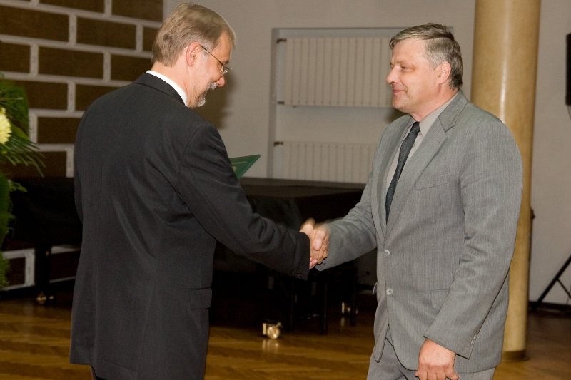 LU darbinieku sapulce. LU rektors Mārcis Auziņš (pa kreisi) pasniedz profesora diplomu Uldim Rogulim.