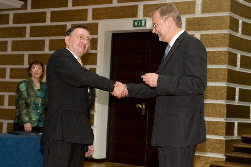 LU darbinieku sapulce. LU rektors Mārcis Auziņš (pa labi) dāvina pildspalvu LU Datorikas fakultātes dekānam Jurim Borzovam.