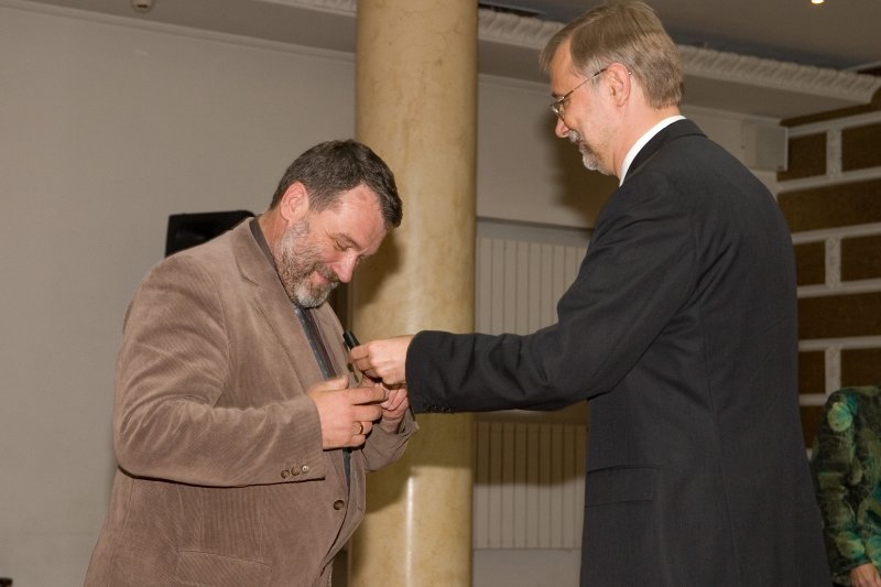 LU darbinieku sapulce. LU rektors Mārcis Auziņš (pa labi) dāvina pildspalvu LU Sociālo zinātņu fakultātes dekānam Jurim Rozenvaldam.