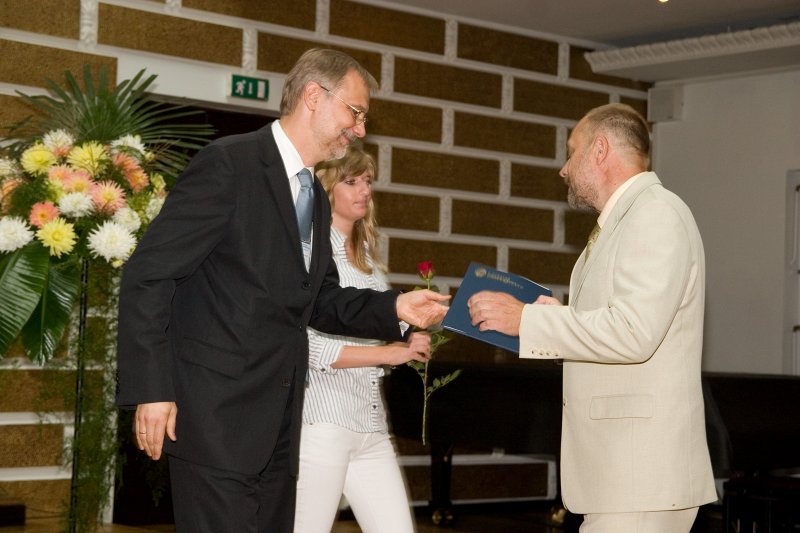 LU darbinieku sapulce. LU rektors Mārcis Auziņš (pa kreisi) pasniedz pateicības rakstu prof. Jānim Švirkstam.