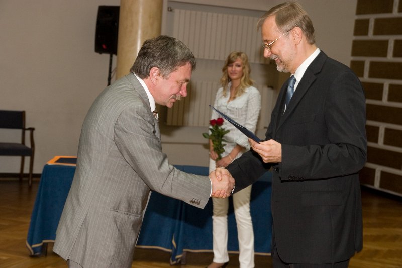 LU darbinieku sapulce. LU rektors Mārcis Auziņš (pa kreisi) pasniedz pateicības rakstu zinātņu prorektoram prof. Indriķim Muižniekam.