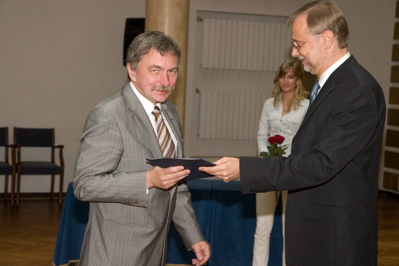 LU darbinieku sapulce. LU rektors Mārcis Auziņš (pa kreisi) pasniedz pateicības rakstu zinātņu prorektoram prof. Indriķim Muižniekam.