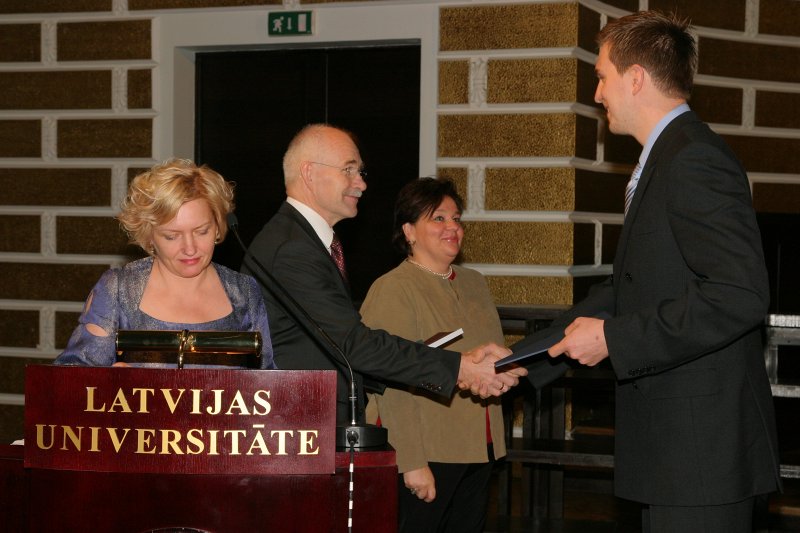 LU Fonda 2009./2010.ak.g. stipendiātu sumināšana. LU Fonda valdes priekšsēdētājs prof. Ivars Lācis un AS 'Sentor Farm Aptiekas' pārstāve Svetlana Grenge sveic stipendijas ieguvēju Uģi Bēru.