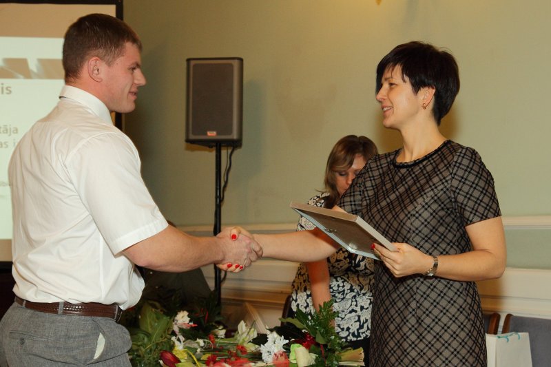 Vernera fon Sīmensa Izcilības balvu (Werner von Siemens Excellence Award) pasniegšanas ceremonija. Siemens Latvijas filiāles vadītāja Maija Baumane sveic balvas saņēmēju RTU maģistru Gundaru Ašmani.