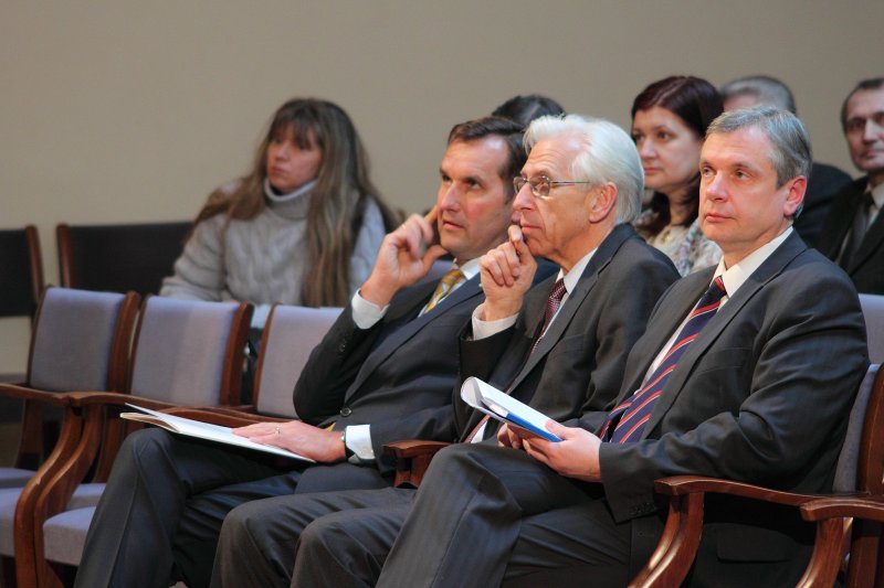 Latvijas Universitātes 68. zinātniskās konferences plenārsēde. No kreisās: 
LR ārlietu ministrs Māris Riekstiņš; 
prof. Edvīns Karnītis; 
LR Saeimas deputāts Kārlis Šadurskis.