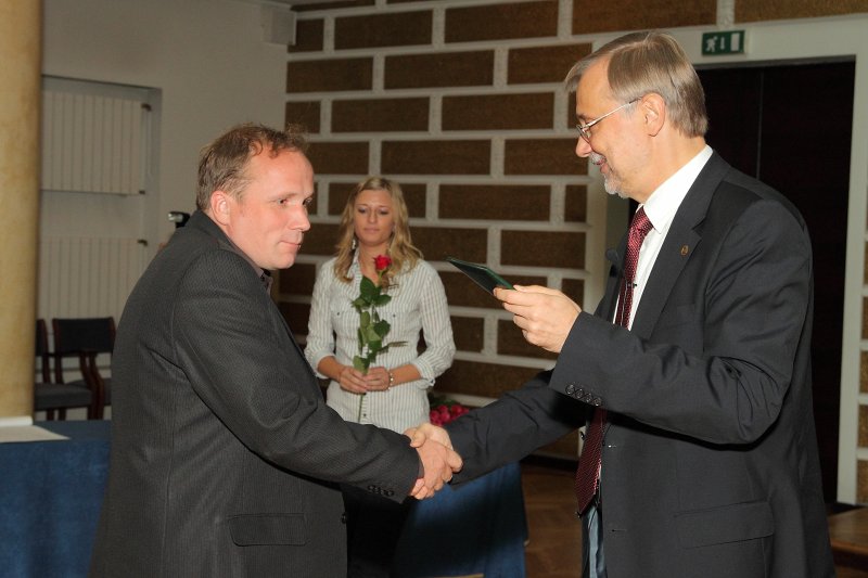 Latvijas Universitātes darbinieku sapulce. LU rektors prof. Mārcis Auziņš (pa labi) pasniedz asoc. profesora diplomu LU HZF asoc. profesoram Jānim Ešotam.