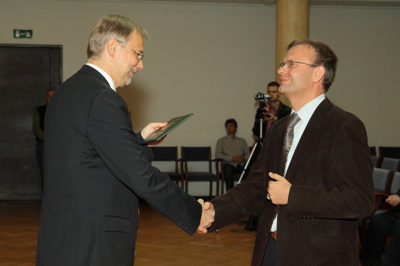 Latvijas Universitātes darbinieku sapulce. LU rektors prof. Mārcis Auziņš (pa kreisi) pasniedz profesora diplomu LU TF profesoram Valdim Tēraudkalnam.
