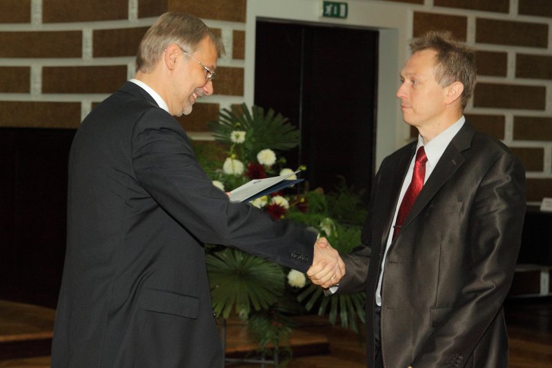 Latvijas Universitātes darbinieku sapulce. LU rektors prof. Mārcis Auziņš (pa kreisi) pasniedz pateicības rakstu Studentu servisa direktoram Jānim Saulītim.
