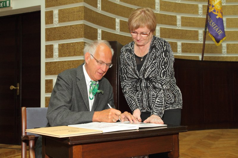 Latvijas Universitātes 91. gadadienai veltīta svinīgā LU Senāta sēde. LU Goda doktors, Tibingenas Universitātes profesors Otfrīds Hefe parakstās LU Goda doktoru grāmatā. Pa labi - LU Senāta zinātniskā sekretāre Ilze Upacere.