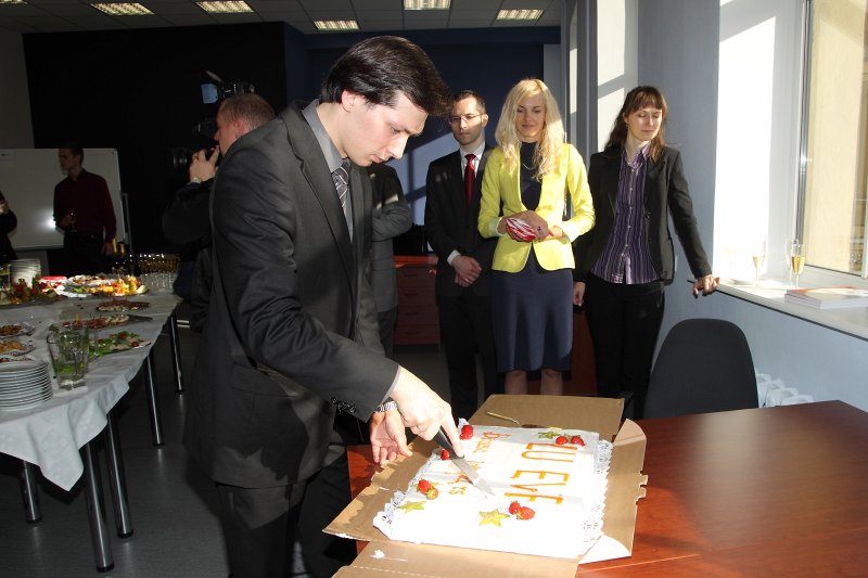 Latvijas Universitātes Biznesa inkubatora atklāšana LU Ekonomikas un vadības fakultātē. Biznesa inkubatora vadītājs Mikus Losāns sagriež svētku torti.
