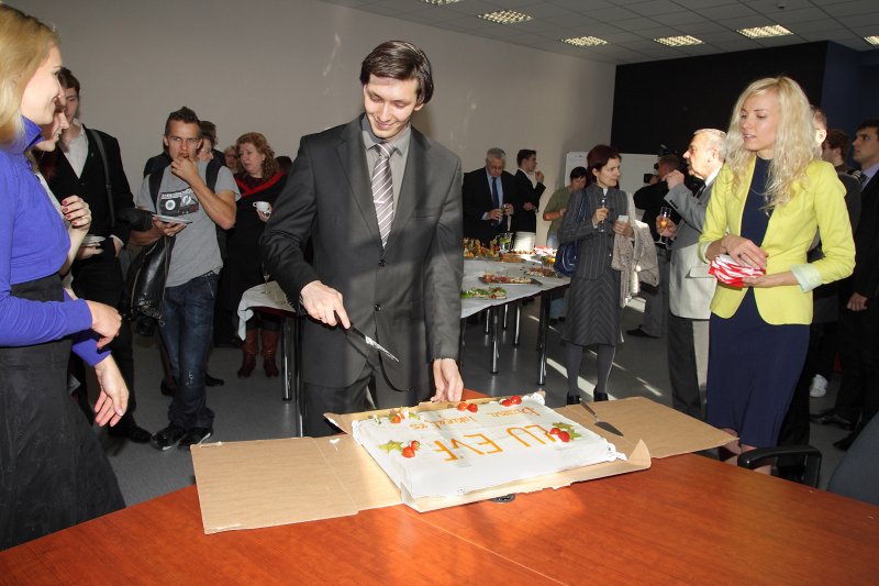 Latvijas Universitātes Biznesa inkubatora atklāšana LU Ekonomikas un vadības fakultātē. Biznesa inkubatora vadītājs Mikus Losāns sagriež svētku torti.