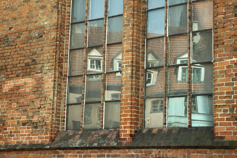 Vecrīga. Skārņu ielas nama atspīdums Rīgas Svētā Pētera baznīcas logā. null