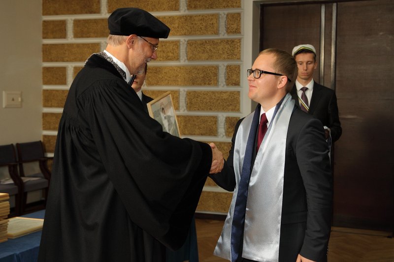 Latvijas Universitātes 94. gadadienai veltīta LU Senāta svinīgā sēde. LU doktoru promocijas ceremonija. LU rektors prof. Mārcis Auziņš pasniedz LU Apliecinājuma rakstu dr. Gatim Litvinam.