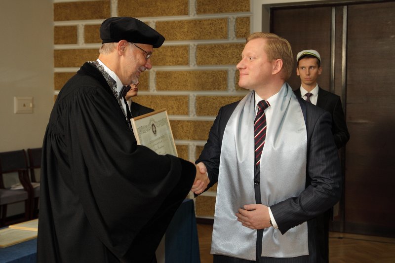 Latvijas Universitātes 94. gadadienai veltīta LU Senāta svinīgā sēde. LU doktoru promocijas ceremonija. LU rektors prof. Mārcis Auziņš pasniedz LU Apliecinājuma rakstu dr. Jānim Rozenbergam.