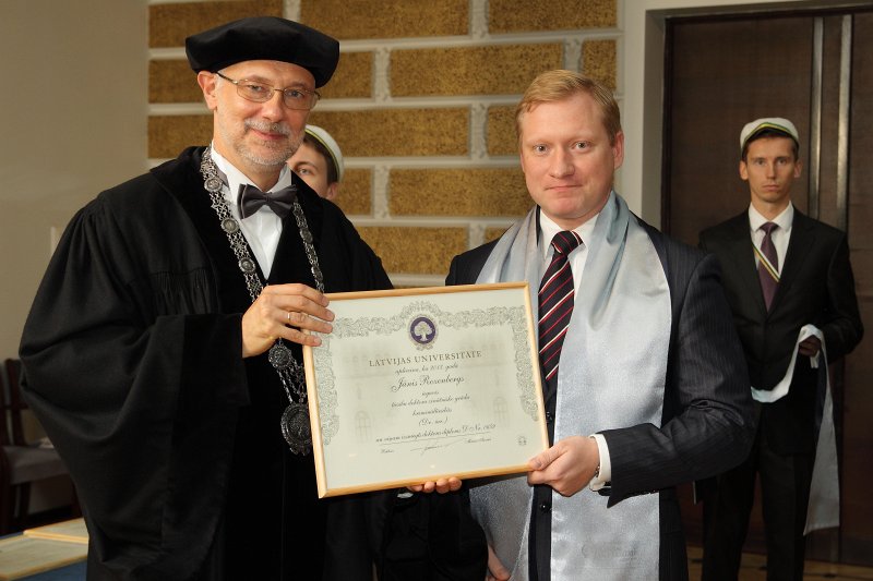 Latvijas Universitātes 94. gadadienai veltīta LU Senāta svinīgā sēde. LU doktoru promocijas ceremonija. LU rektors prof. Mārcis Auziņš pasniedz LU Apliecinājuma rakstu dr. Jānim Rozenbergam.