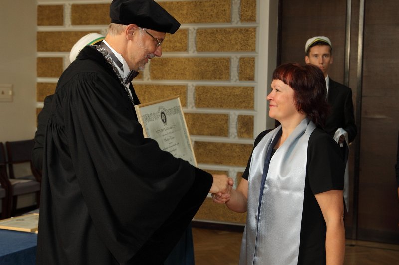 Latvijas Universitātes 94. gadadienai veltīta LU Senāta svinīgā sēde. LU doktoru promocijas ceremonija. LU rektors prof. Mārcis Auziņš pasniedz LU Apliecinājuma rakstu dr. Inetai Robiņai.