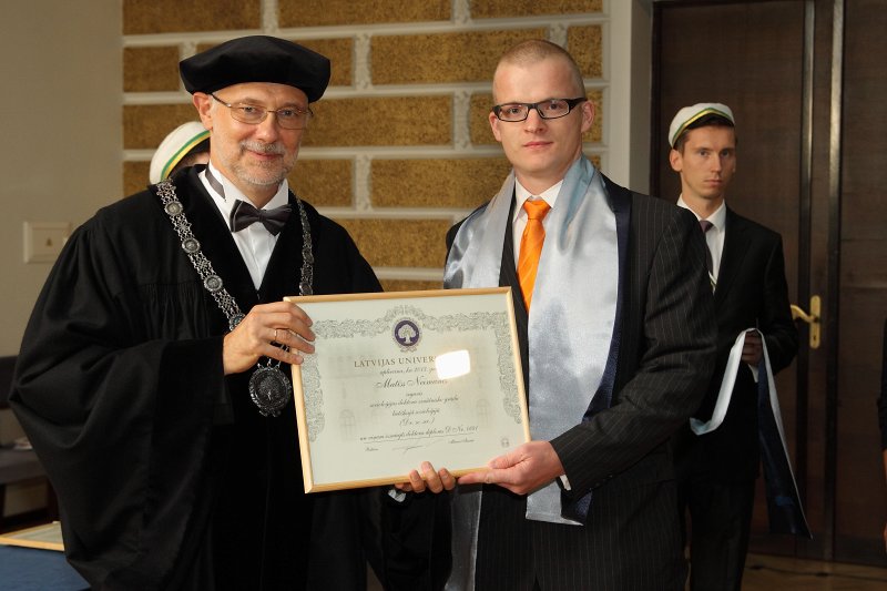 Latvijas Universitātes 94. gadadienai veltīta LU Senāta svinīgā sēde. LU doktoru promocijas ceremonija. LU rektors prof. Mārcis Auziņš pasniedz LU Apliecinājuma rakstu dr. Matīsam Neimanim.