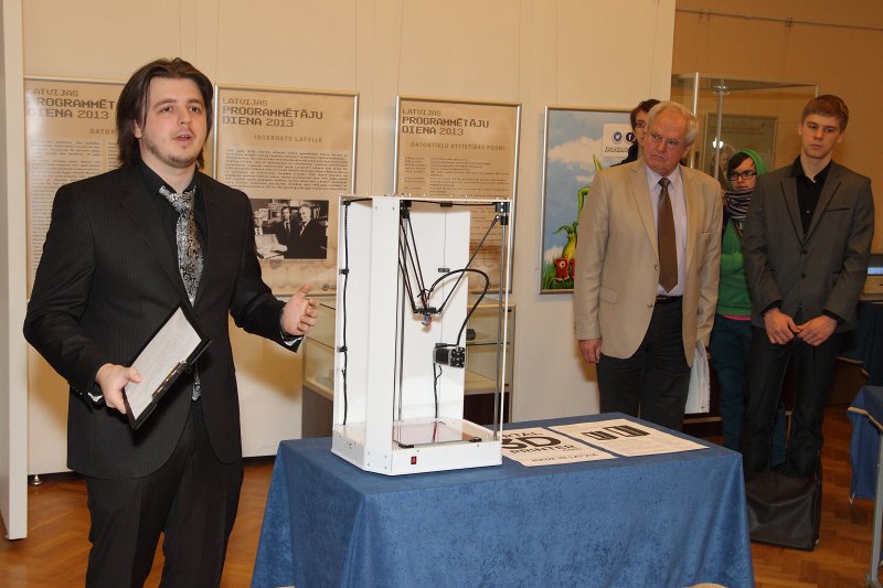 Latvijas Programmētāju dienai veltītas izstādes «Datorika Latvijā» atklāšana LU Zinātņu un tehnikas vēstures muzeja telpās. Latvijas Universitātes Datorikas fakultātes studentu pašpārvaldes priekšsēdētājs Andris Eniņš prezentē Latvijā izgatavotu 3D printeri.