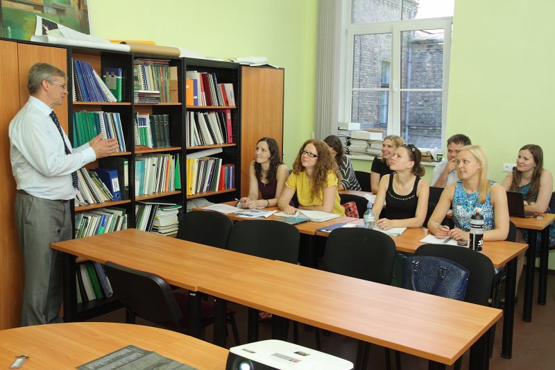 Latvijas Universitātes Ģeogrāfijas un Zemes zinātņu fakultātes 
dekāns prof. Oļģerts Nikodemus un studenti auditorijā. null