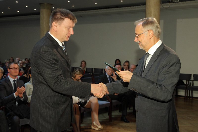 Latvijas Universitātes darbinieku sapulce. LU rektors prof. Mārcis Auziņš (pa labi) pasniedz asoc. profesora diplomu LU FMF asoc. profesoram Sandrim Lācim.