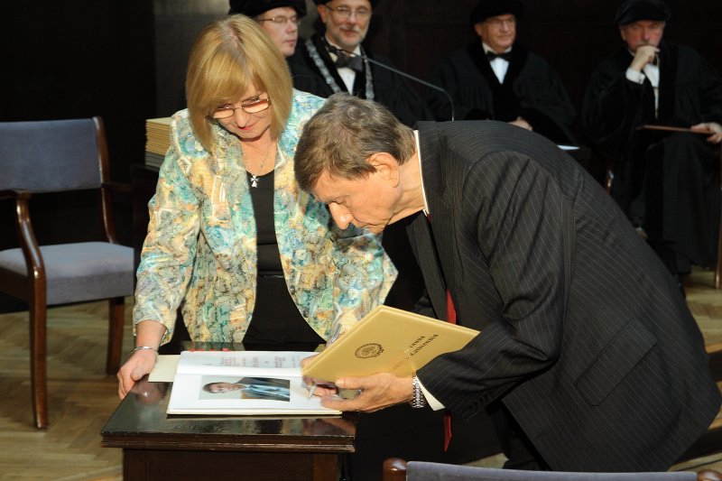 Latvijas Universitātes 95. gadadienai veltīta LU Senāta svinīgā sēde. LU Goda doktors, 
Viļņas Universitātes profesors Alberts Čaplinsks  (Albertas Čaplinskas) 
parakstās LU Goda doktoru grāmatā.