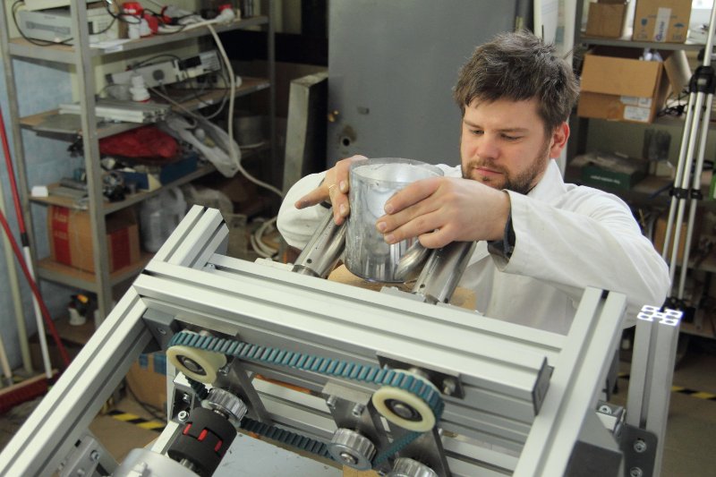 Latvijas Universitātes Fizikas institūta pētnieks Toms Beinerts pie viņa izstrādātā magnētiskā šķidra metāla maisītāja prototipa. null