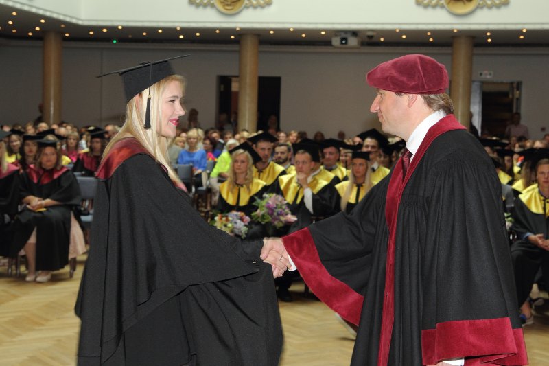 Latvijas Universitātes Biznesa, vadības un ekonomikas fakultātes absolventu izlaidums. LU BVEF dekāns asoc. prof. Gundars Bērziņš sveic absolventi.
