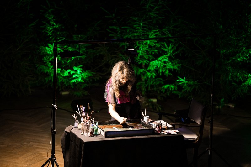 Latvijas Universitātes Ziemassvētku koncerts «Ceļā uz gaismu». Gleznojumus Ebru tehnikā veido māksliniece Anda Kolosova.