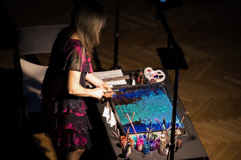 Latvijas Universitātes Ziemassvētku koncerts «Ceļā uz gaismu». Gleznojumus Ebru tehnikā veido māksliniece Anda Kolosova.