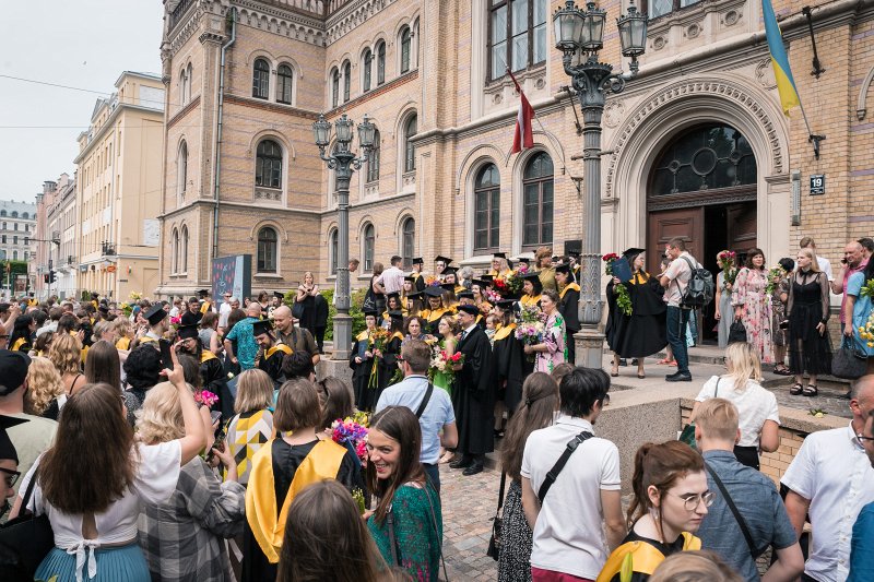 Absolventi un viesi pēc izlaiduma pie Latvijas Universitātes galvenās ēkas. null